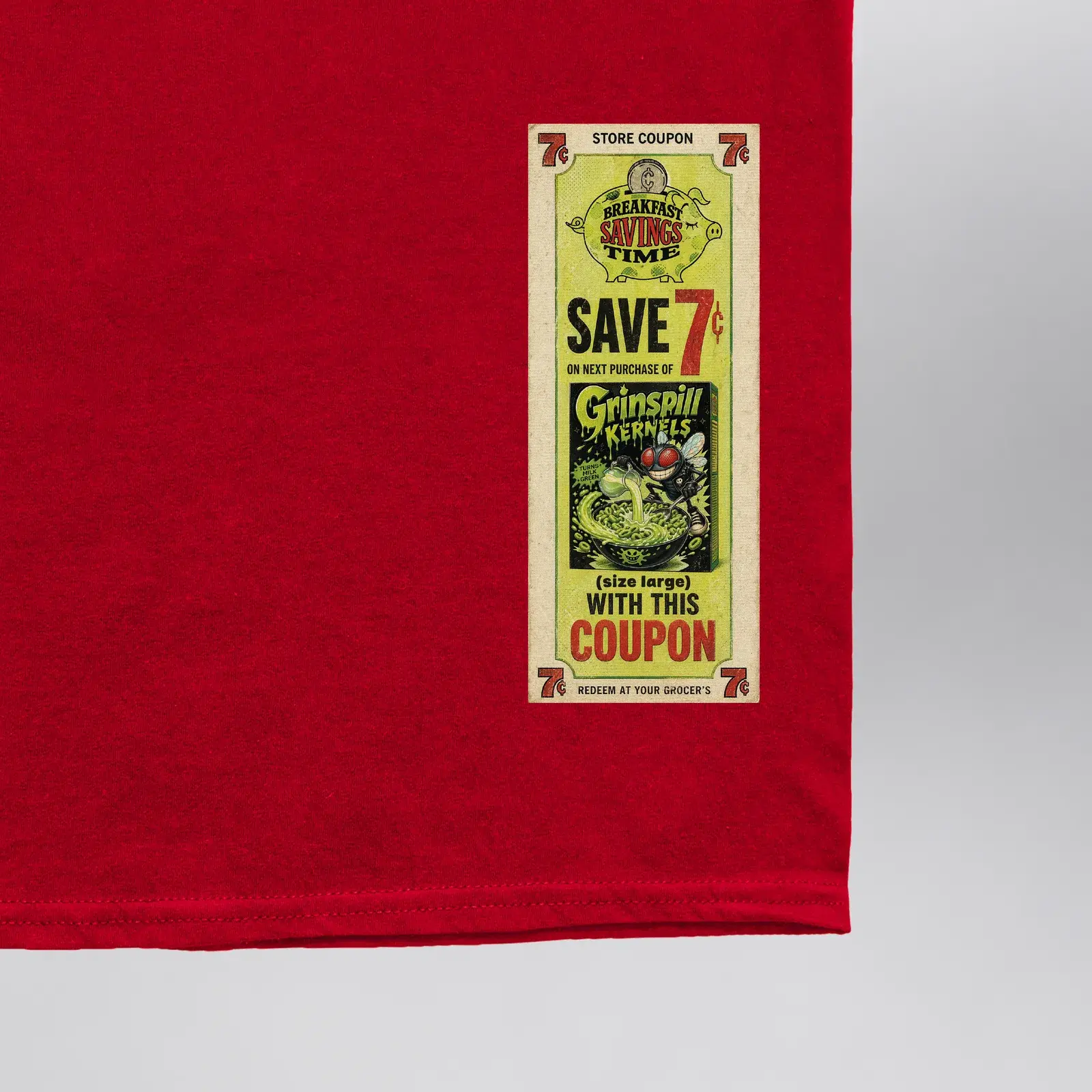 Grinspill Kernels Red Kernel Club Tee (Exclusive 1 of 1), close-up of the “Save 7¢” Grinspill Kernels store coupon on the front hem