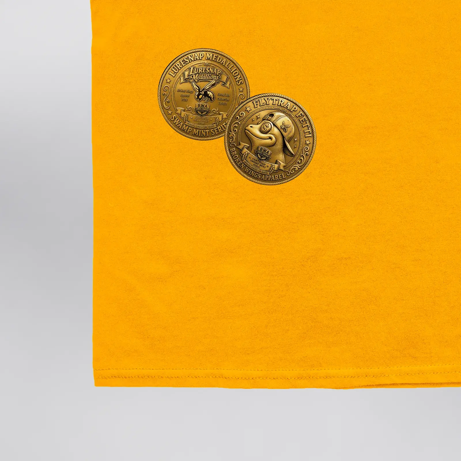 Luresnap Medallions Golden Ticket Tee (Exclusive 1 of 1), close-up of the two Luresnap Medallions coins on the back hem
