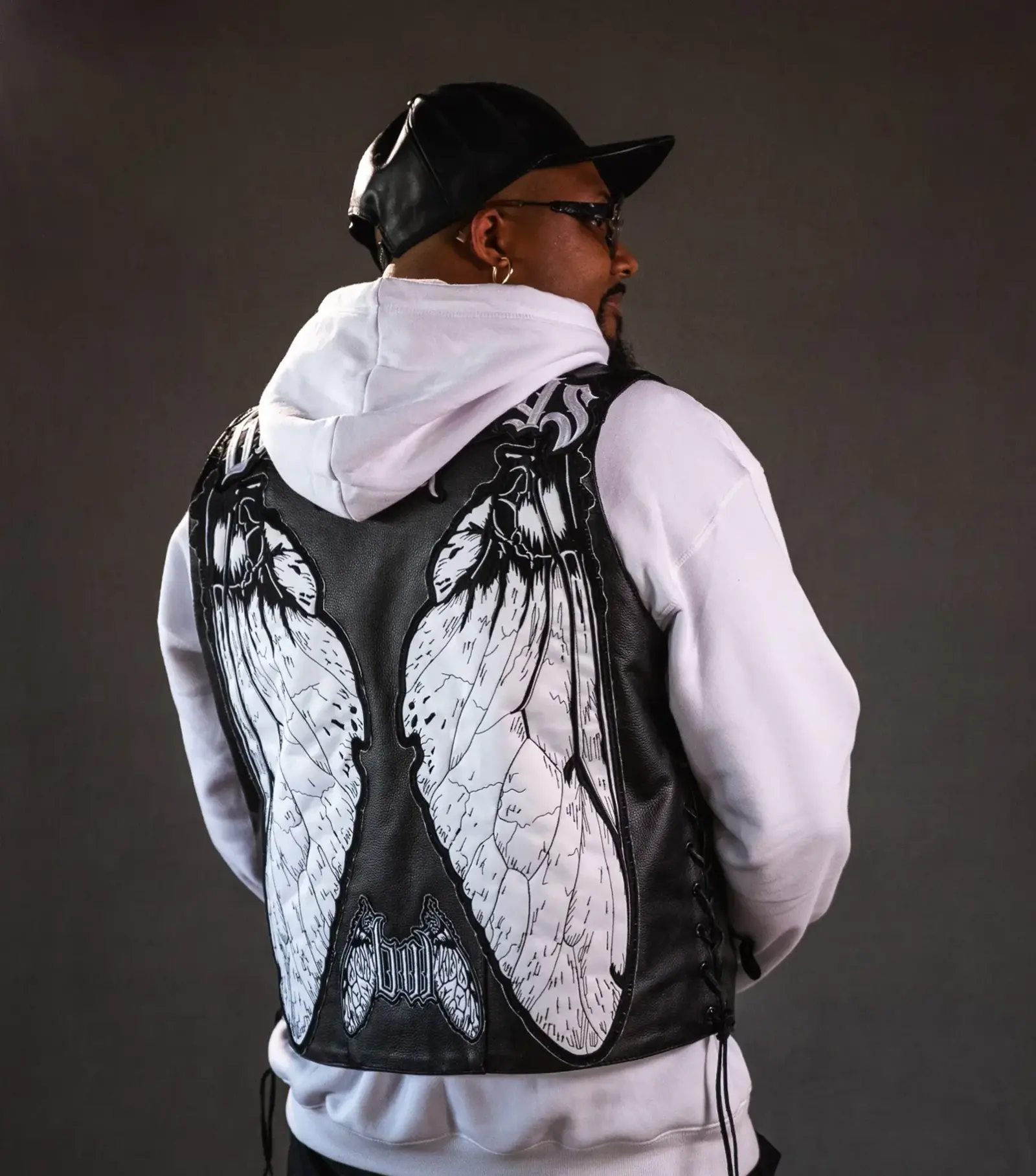 The embroidered winged leather vest, worn from behind.
